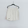 A pair of white running shorts hanging on a hanger against a plain wall.